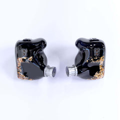 Moritz Audio ENZO Flagship In Ear Monitors. Pair of glossy black in-ear monitors with gold flake accents and silver nozzles, on white background.