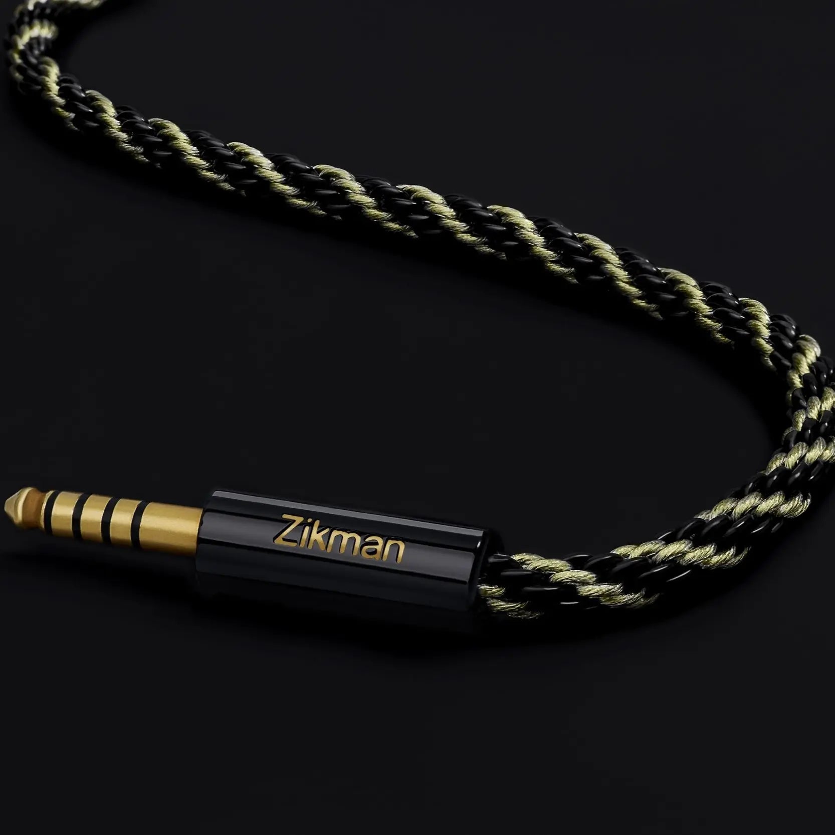 Rope-style audio cable with gold and black connector on a dark background, featuring the brand 'Zikman'.