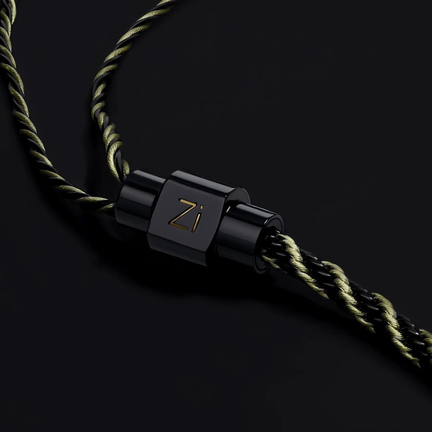 Black metal clasp with 'Zi' branding on a braided cord against a dark background