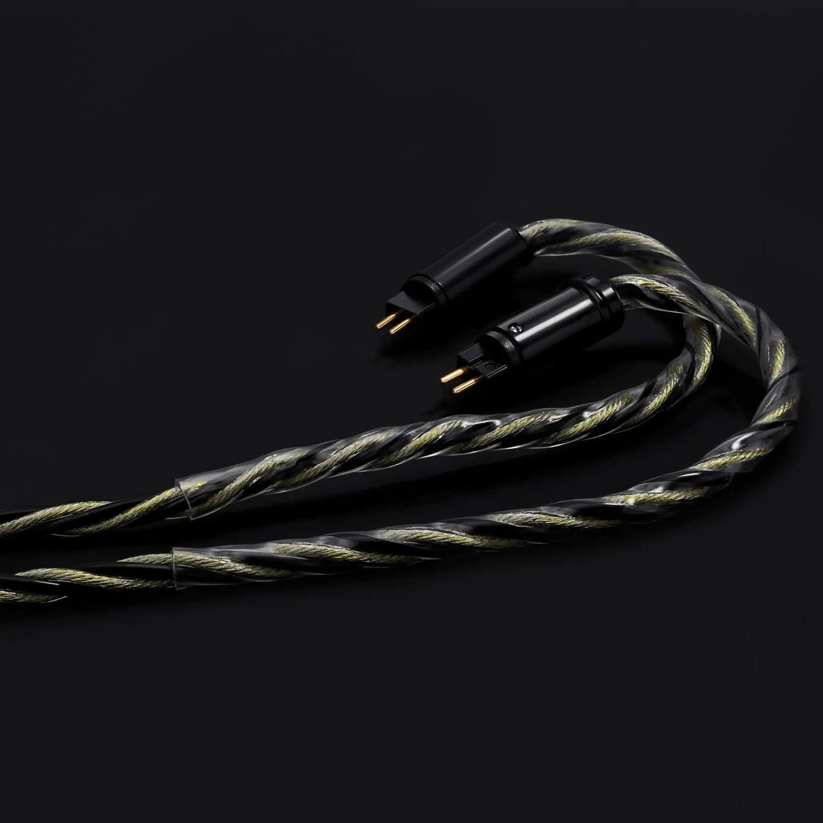 Coiled audio cable with gold connectors on a black background