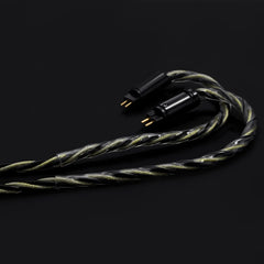 Coiled audio cable with gold connectors on a black background